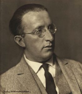 Erich Mendelsohn's portrait . He seems to be starring at something to the right. He has glasses and his wearing a tie and jacket. 