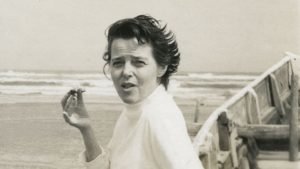 Charlotte Perriand portrait: She holds something small in her right hand. 