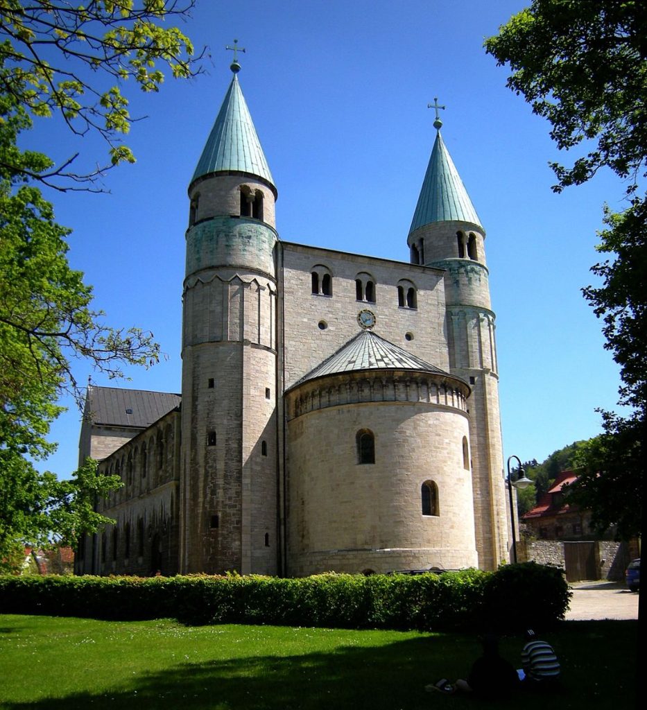 The westwerk of St. Cyriakus in Gernrode: A large structure with a semicircular dome surrounded by a pointed tower on either side. 