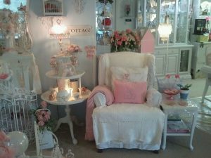 shabby cottage style: A photo of the interior of a house, mostly white and pink, the room is excessively decorated. 