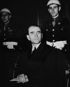 Albert Speer at the Nuremberg trial: Black and white photo of Speer and two guards in the background