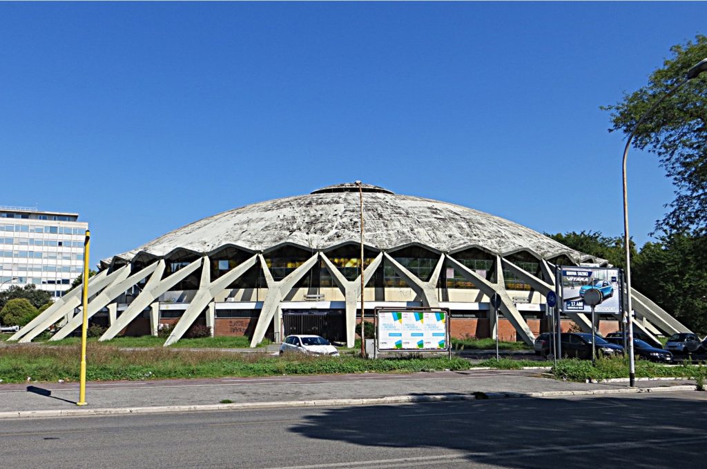 Exterior of Palazzetto dello Sport, which is a semi-short light-colored dome. 