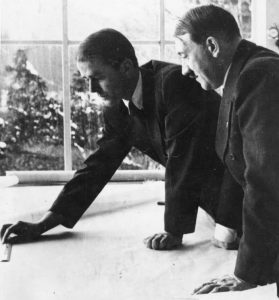 Speer shows Hitler a project at Obersalzberg: Two men stand over Speer's work. 