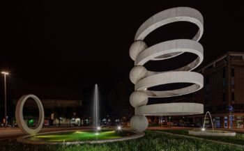 Un'opera d'arte grande e a spirale che sembra essere all'esterno di un quadrato. Fontana di Carmelata: 