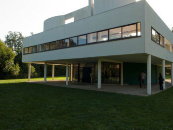 Ville Savoye: A large white structure shown from the exterior. The upper-level sits above the exterior porch, which is supported by various columns. 