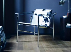 Fauteuil LC1 (fin des années 1920) par Le Corbusier, Pierre Jeanneret et Charlotte Perriand : Une chaise fine en métal avec des coussins imprimés vache.