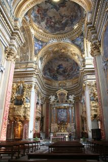 Parte interior de la Iglesia Nueva en Roma. Una cámara doble con una cúpula dorada con varias imágenes religiosas.