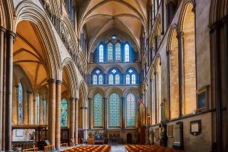 Lado oriental de la Catedral de Salisbury en Estilo Gótico. La pared está cubierta por ventanas arqueadas separadas en 3 filas distintas. Además, los arcos se pueden ver desde ambos lados de las ventanas en toda la catedral.