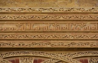 Grande Mesquita de Córdova, pormenor exterior visto na pedra, inscrição cor de areia na parede. 