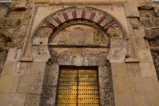 Exemplo de um arco em ferradura na Grande Mesquita de Córdova. Embora a pedra esteja a perder a cor, a porta é de um amarelo vibrante. 