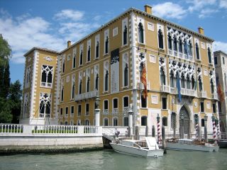Palacio Cavalli-Franchetti ejemplo de arquitectura Gótica-Veneciana. Una grande estructura rectangular que se encuentra a lo largo del Canal Grande de Venecia. Además, esta estructura de color mostaza tiene ventanas arqueadas blancas con varias decoraciones.