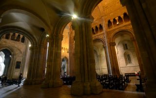 Catedral Patriarcal de Santa Maria Maior. A fotografia mostra o interior da catedral com várias colunas a suportar o tecto e recortes de janelas ao longo das paredes. 