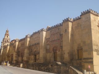 Grande Mesquita de Córdova em estilo mourisco. Uma grande estrutura cor de areia com colunas rectangulares que se fixam para fora ao longo do bordo da estrutura.  