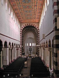 Iglesia de San Miguel Hildesheim en Estilo Otoniano. Una iglesia con un estilo simple, con arcos a la derecha e izquierda. La nave con bancos de madera oscuro conduce al altar en la zona de la cúpula.