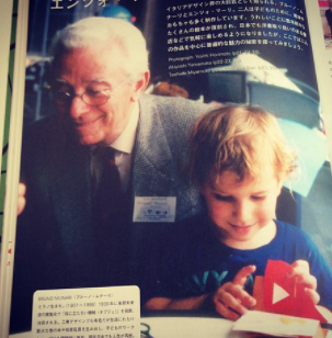 Bruno Munari's photo with a child playing with a red toy.