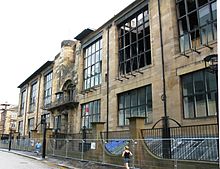 Scuola d'arte di Glasgow, progettata da Charles Rennie Mackintosh. Foto dell'edificio in pietra di colore chiaro con finestre scure.