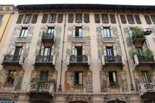 Casa Galimberti a Milano, architettura Liberty. Un grande edificio con quattro piani e finestre elaborate tutte con balconi in metallo. 