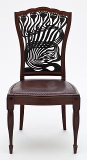 Cadeira desenhada por Arthur Mackmurdo. O encosto é abstracto, decorado com motivos que lembram flores ou plantas. 