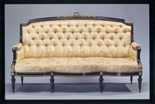 Sofá Estilo Luís Filipe . Um sofá amarelo claro com uma base em madeira de ácer. É também adornado com flores de bronze. 