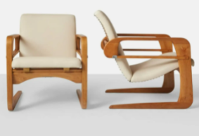 KEM Weber "Airline" armchairs (1934): light wood chairs with white cushions. They appear to have slight rocking capabilities. 