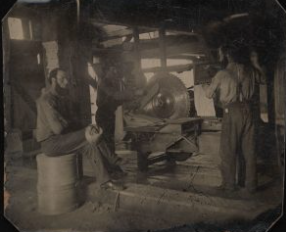 Interior of a mill showing three men using a circular saw, Maberly, Ontario.