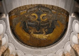 Arc of the Covenant: photo of the mosaic ceiling of a dome-shaped building. There are two divine creatures that meet in the middle. 
