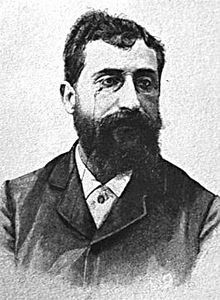 Ernesto Basile, portrait in black and white. He is depicted with a monocle, and a long, dark beard. Moreover, the photo is very grainy. 
