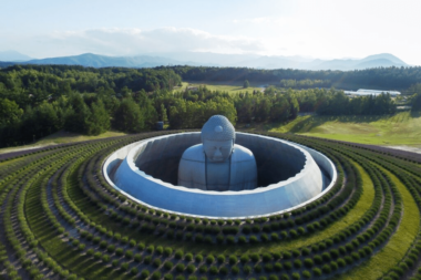 Hill of the Buddha, 2015, by Tadao Ando; the statue of the Buddha peaks out of a circular hole, located at the center of a lawn.