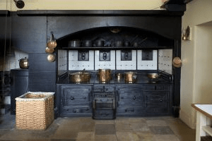 Industrial Style Interior of a kitchen with black cabinets and gold cookware.