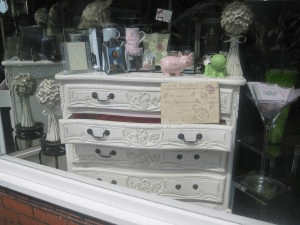 Shabby Chic Furniture: A decorated dresser with dark hardware. 
