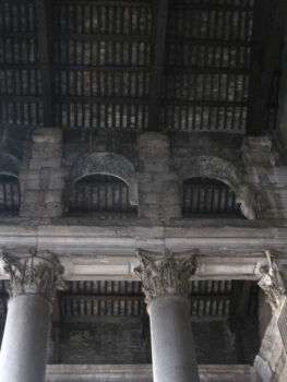 Il soffitto del Pantheon mostrato dal basso verso l'alto. Ci sono due archi raffigurati e colonne situate sotto di loro. 