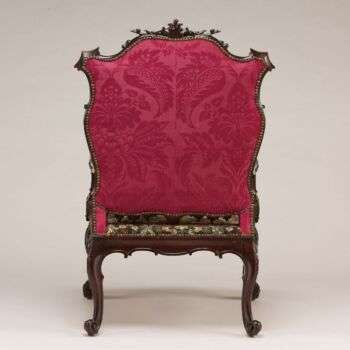 Additional photo of the back of the armchair. The back of the chair is seen with a vibrant pink upholstery. 