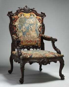 Armchair, After a design by Thomas Chippendale. A dark wood piece with intricate cushion details and elaborate flourishes. 