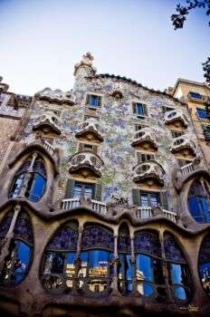 Casa Batllo (1906) -  Gaudì: A large elaborate building with ornamental balconies and oval window openings. 
