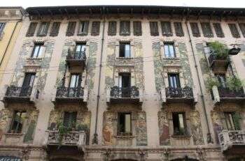Milano - Casa Galimberti: A large building with four floors and elaborate windows all with metal balconies. 
