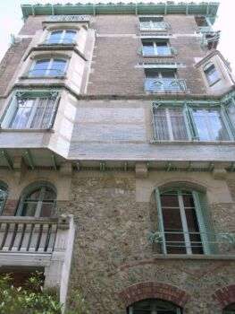 Castel Béranger, Guimard, 1894-1898, Paris : la façade d'un immeuble parisien en matériau léger avec des fenêtres garnies de métal vert.