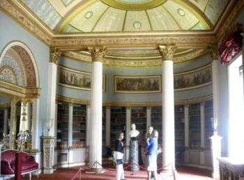 Photo of the rotunda and library in Kenwood House library. The walls are a pale blue with white and gold accents throughout the room. 