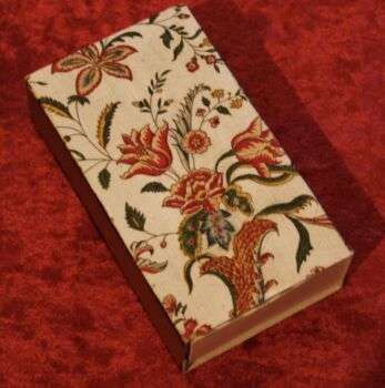 Decorated matchbox with big red flowers and green leaves. 