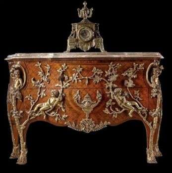 French Regency style ormolu mounted commode in a medium wood with light colored metal accents. 