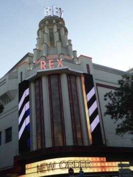 Grand Rexx, cinema de Paris. Foto da fachada exterior, estruturalmente desproporcional e com grandes luzes de néon e uma torre art déco.