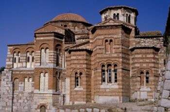 Hosios Loukas Monastery: A brown stone building with various skinny arched windows. 