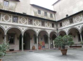 Firenze, lo Spedale degli Innocenti: Una grande struttura con un cortile al centro e archi sulle porte dell'interno. 