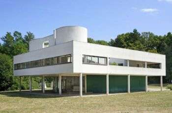 La Villa Savoye de Le Corbusier (Poissy, França): Um edifício branco com um topo rectangular, um toldo que percorre todo o edifício e longas janelas rectangulares. 