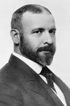 Louis Sullivan, circa 1895: A black and white portrait of a stern-looking man with a nice suit on. 