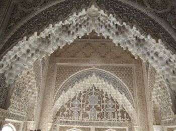 The ornate, white stone ceiling of the Palace of the Lions, located in Granada Spain. 