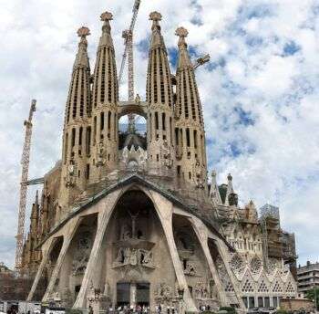 Sagrada Familia - Passion façade: A large sharp structure with four distinct, pointy towers and an arched entrance. 