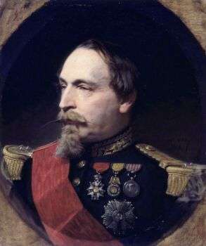 Portrait of Napoleon III in traditional attire. Moreover, he has a long, skinny beard and pal white skin.