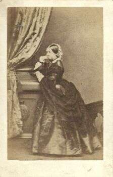 Queen Victoria by Mayall, 1 March 1861: Photo of her in a dark gown with a light-colored hair piece. 