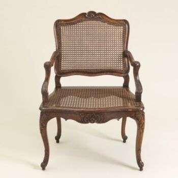Régence style chair with dark wood legs and a basket-like seat and back. 