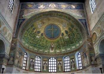 Photo of the mosaic ceiling of the Sant'Apollinare in Classe, Ravenna. The mosaic depicts Jesus under a cross with various vegetation and sheep surrounding him. 